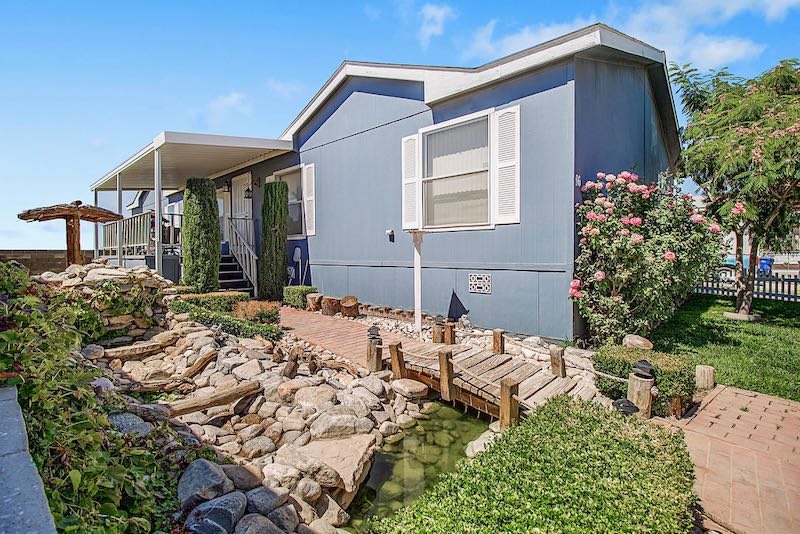 Blue House with White Trim and Pebble Pond