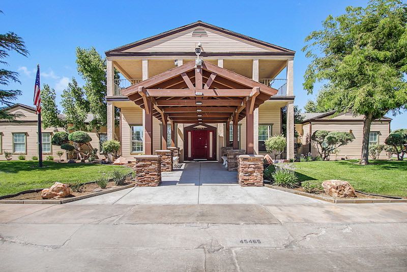 Clubhouse entrance with large lawn and clear skies