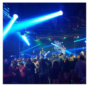 Crowd of people attending a live show with spotlights
